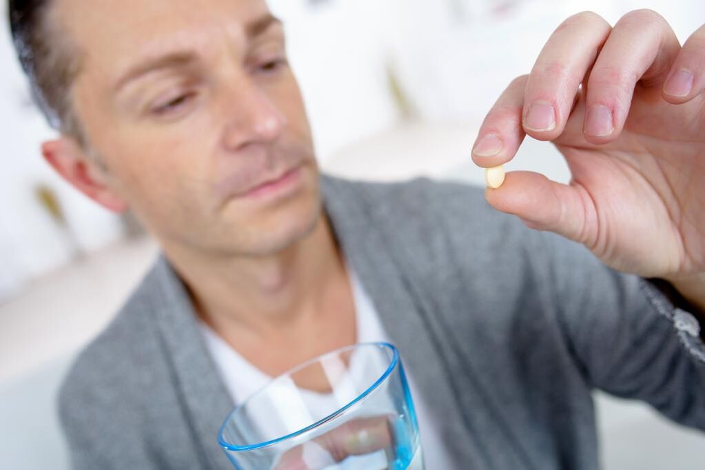 a man takes a pill to increase his potency