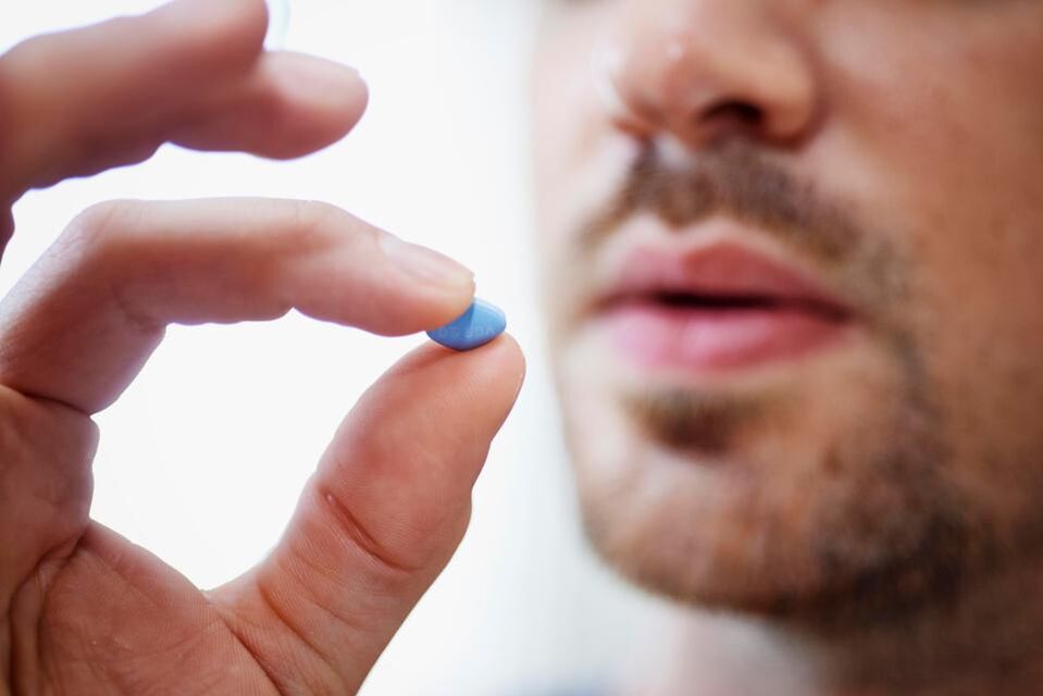 a man takes a pill to boost potency